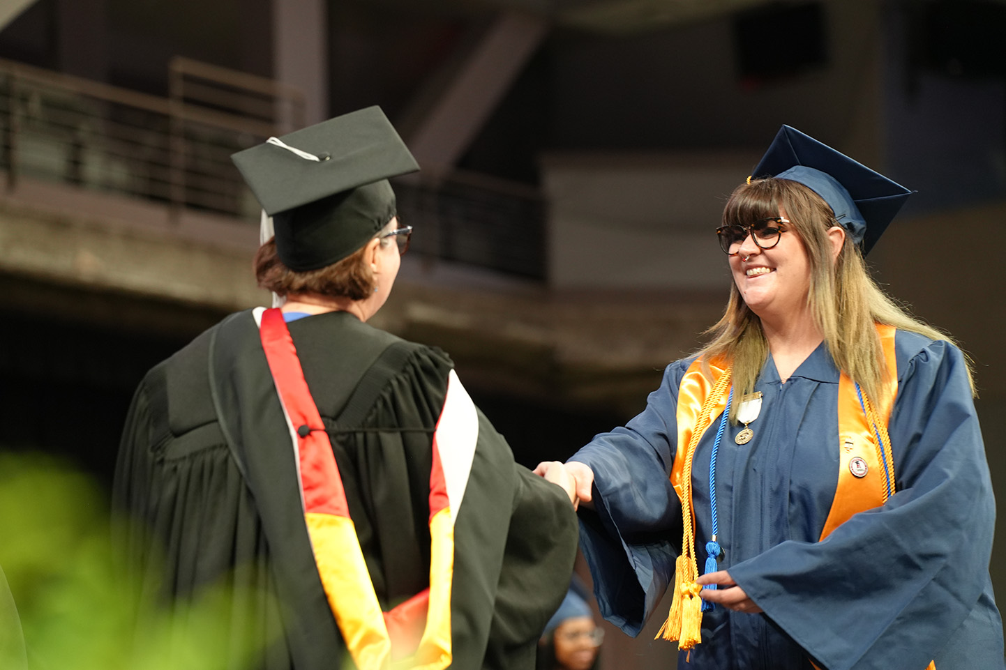 Joeanna Moore walkng across stage at commencement